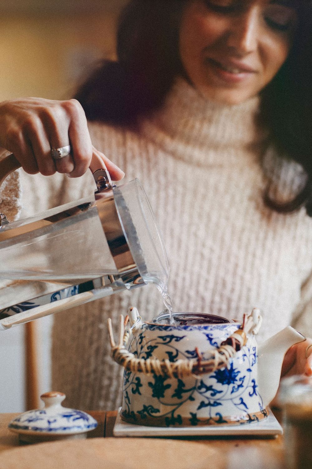 Zsofia pouring hot water into a blue and white teapot