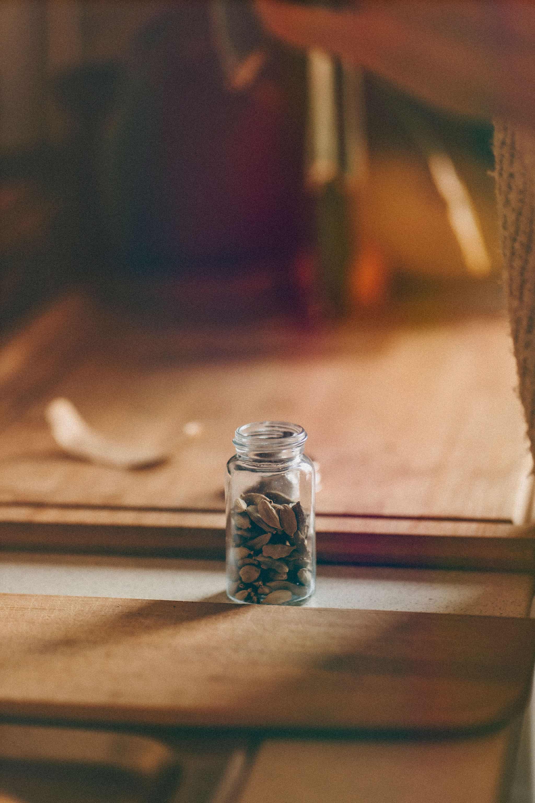 A jar of cardamom in window light